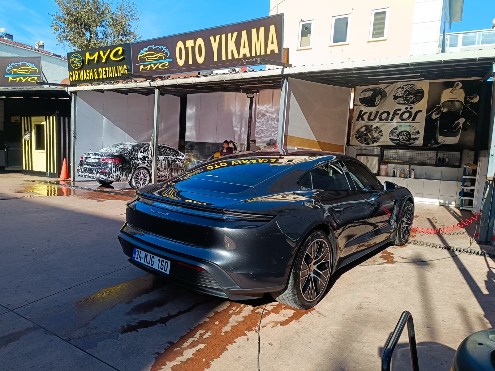 MYC Car Wash & Detailing önünde yıkanmış koyu renkli spor otomobil